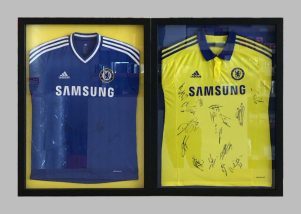 Shadowboxes containing signed football shirts